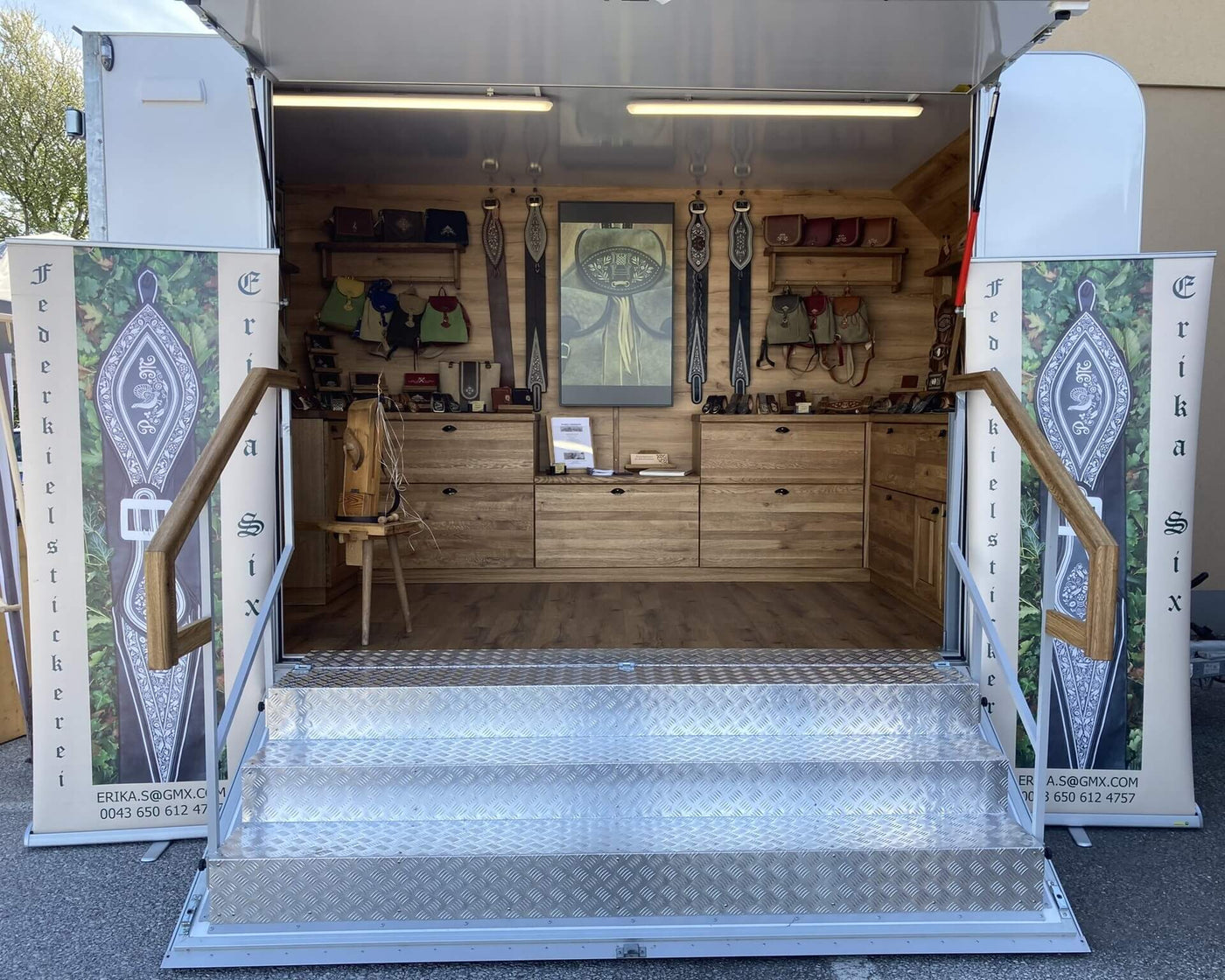 obiler Messeanhänger von Six Federkielstickerei für Outdoor-Ausstellungen in Österreich und Bayern, mit traditioneller Federkielstickerei zum Live-Erleben.
